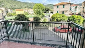 Un balcón con vista a un estacionamiento, edificios y una colina.