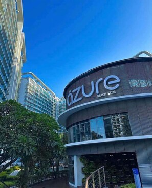 A modern building with the sign 'Azure Beach Club' indicating a hotel or resort. - Her Casa Stays (Paranaque)