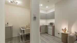 Una cocina moderna con gabinetes grises, encimera blanca y horno empotrado.