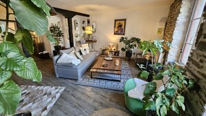 A cozy living room with a sofa, coffee table, and potted plants. - Duplex standing 3 beds sea view - terrace/ Cancale (Cancale)
