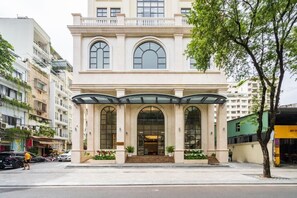 A multi-story building with a classical architectural style, featuring arched windows and a central entrance with steps. - Tao Dan Hotel (Ho Chi Minh City)