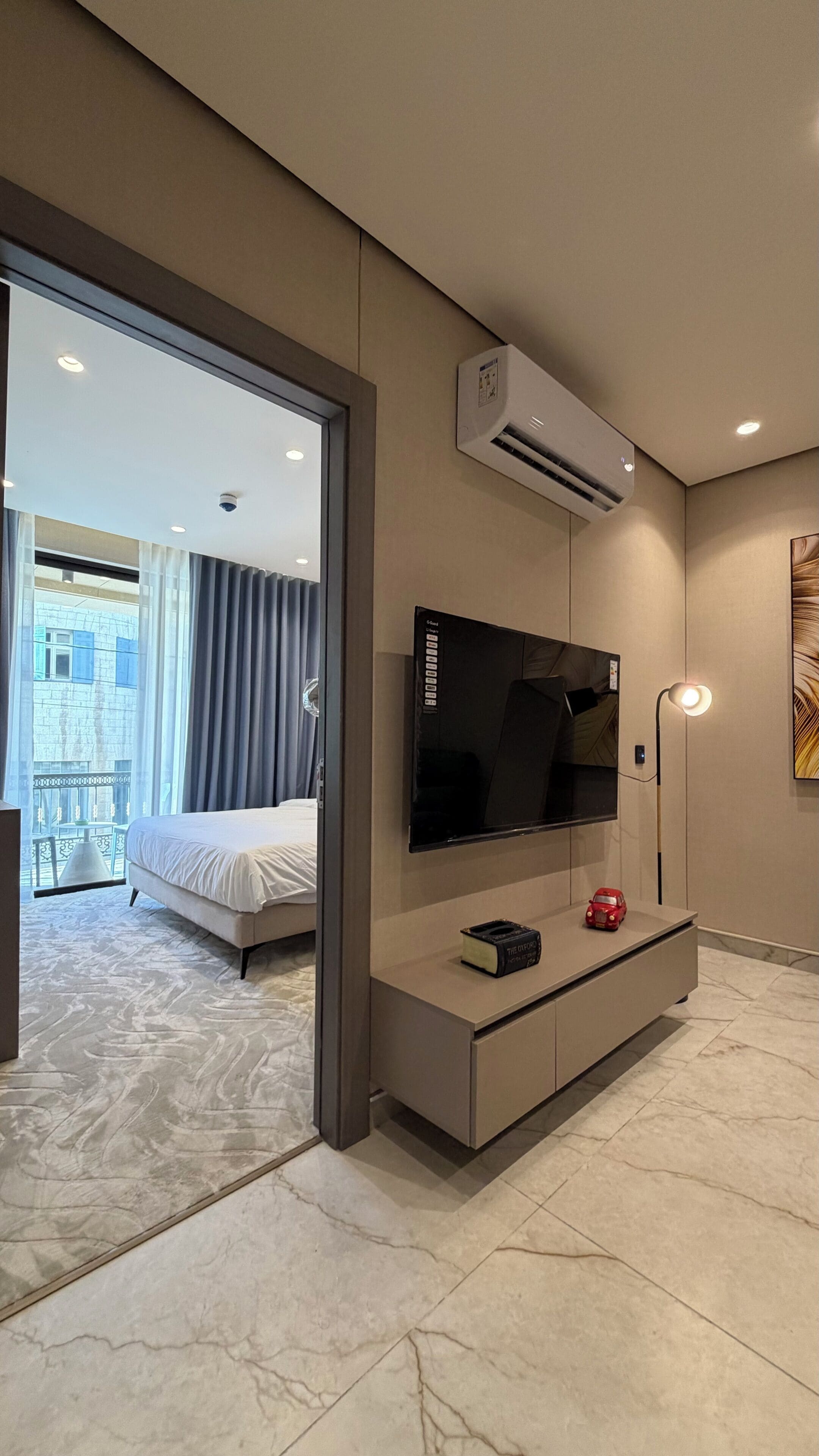 Ein Hotelzimmer mit Bett, Flachbildfernseher, Minibar und Klimaanlage.