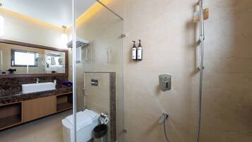 Un baño moderno con cabina de ducha de vidrio, un lavamanos y un espejo.