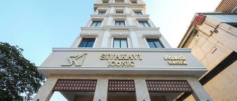 Un edificio con un letrero que dice 'SIVAKAVI ICONIC' y una señal de bar arriba.