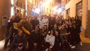 Un grupo de personas reunidas en una calle por la noche.