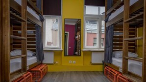 Un dormitorio con literas, un espejo y una ventana.
