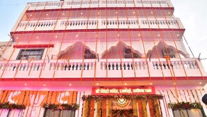 A multi-story building with balconies and a decorative entrance. - Shree Videhi Atithi Grah (Samudrapur)