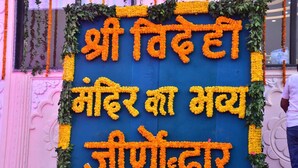 A wall with floral decorations and text in a foreign language. - Shree Videhi Atithi Grah (Samudrapur)
