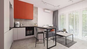 Een moderne keuken met een eethoek, met een kookeiland, barstoelen en uitzicht op groen door grote ramen.