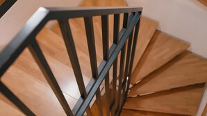 A spiral staircase with wooden steps and black metal railings. - Muskatellerhaus Holiday Home with Shared Pool, Private Terrace, and Wi-Fi (Auggen)