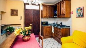 Une cuisine compacte dotée de meubles en bois, d’un four à micro-ondes et d’un coin repas avec une table et des chaises.