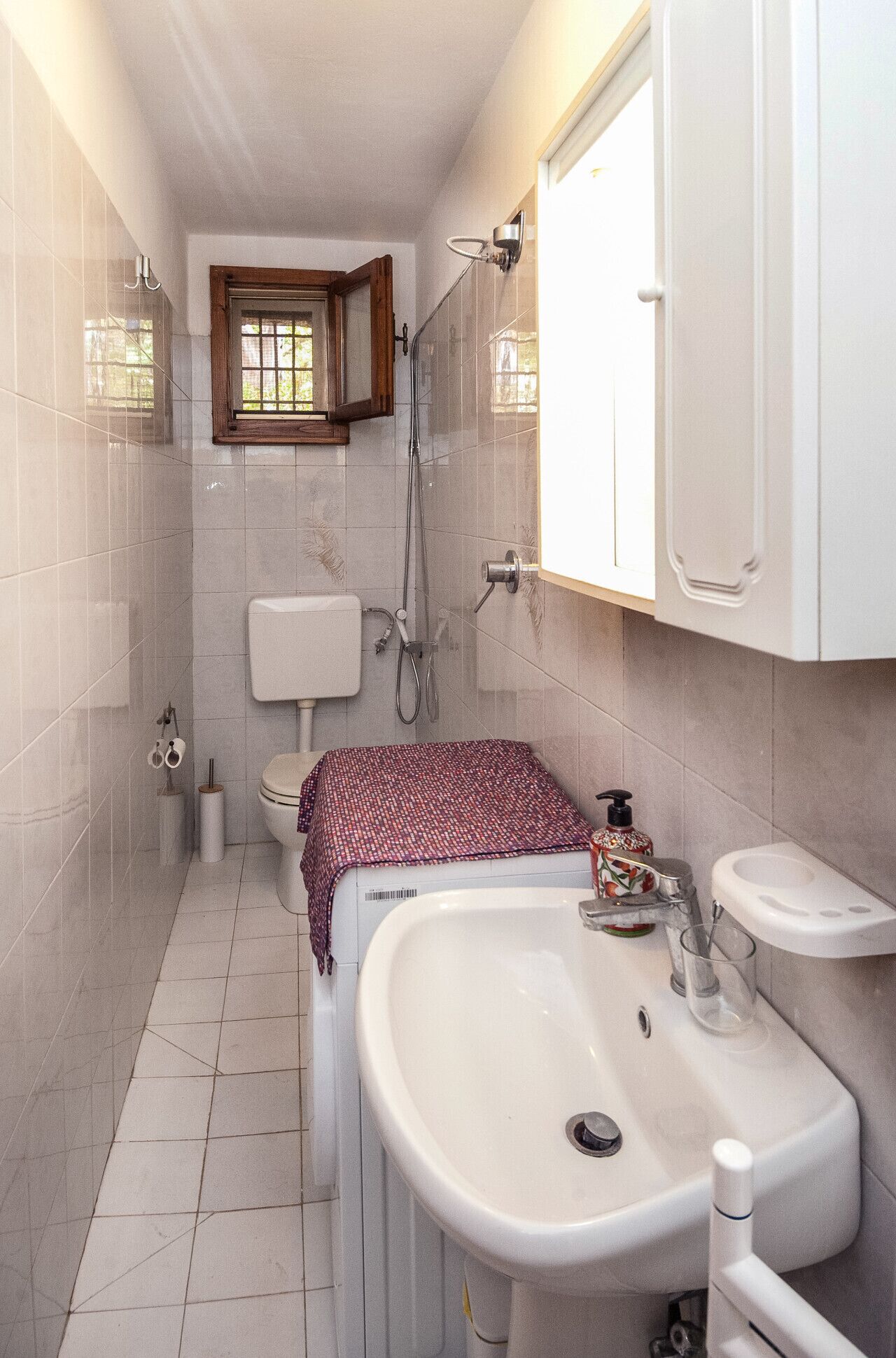 A bathroom with a toilet, bidet, sink, and mirror.