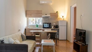 A compact living space with a kitchenette, a dining area, and a seating area. - Kerameikos Radio-Apartments (Athina)