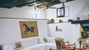 Un coin repas avec une table en bois dressée pour quatre personnes, entourée de chaises en bois dont les assises sont en osier tressé.
