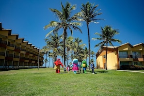 A hotel courtyard with palm trees and a building with balconies.