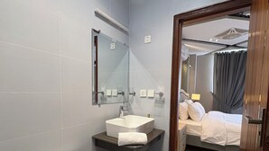 Moderni kylpyhuone, jossa on wc, pesuallas ja peili.