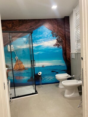 Ein Badezimmer mit Duschkabine, Toilette und Waschbecken.