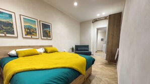 Ein Hotelzimmer mit einem Bett, einem Sessel und einer Tür zu einem anderen Raum.