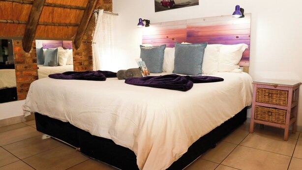 Ein Schlafzimmer mit Bett, Kopfteil, Nachttisch und Spiegel.