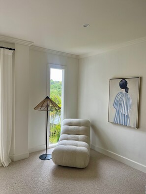 A room with a large window, a standing lamp, a cushioned chair, and a framed artwork on the wall. - Peaceful home perfect for families (Forestville)