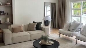 Un salon moderne avec un canapé, une table basse et une bibliothèque.