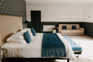 Una camera da letto moderna con un letto, un comodino, una poltrona e carta da parati decorata.