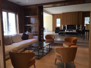 A modern living room with a sofa, armchairs, a coffee table, and a fireplace. - Estate with a lake and recreational activities for the whole family: Vacation Rental, Manor House, and Tipis (Montigny-le-Chartif)