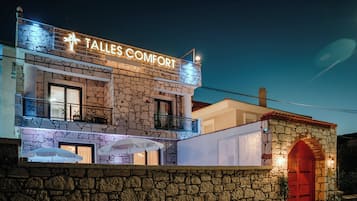 A stone building with a sign reading 'TALLES COMFORT' and a red door.