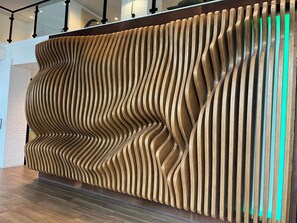 Ein moderner Empfangstresen mit einem einzigartigen, wellenförmigen Holzdesign.
