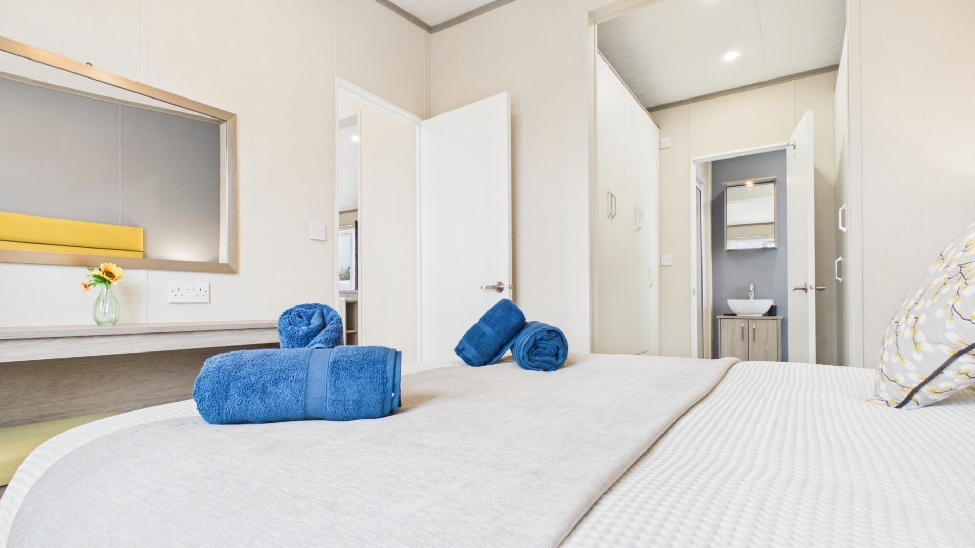 A hotel room with a bed, a bathroom, and a mirror.