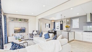 Een moderne woonkamer met een televisie, bank en een eethoek.
