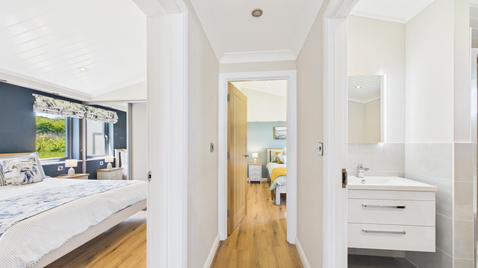 A bedroom with a bed, bedside table, and a window with curtains.