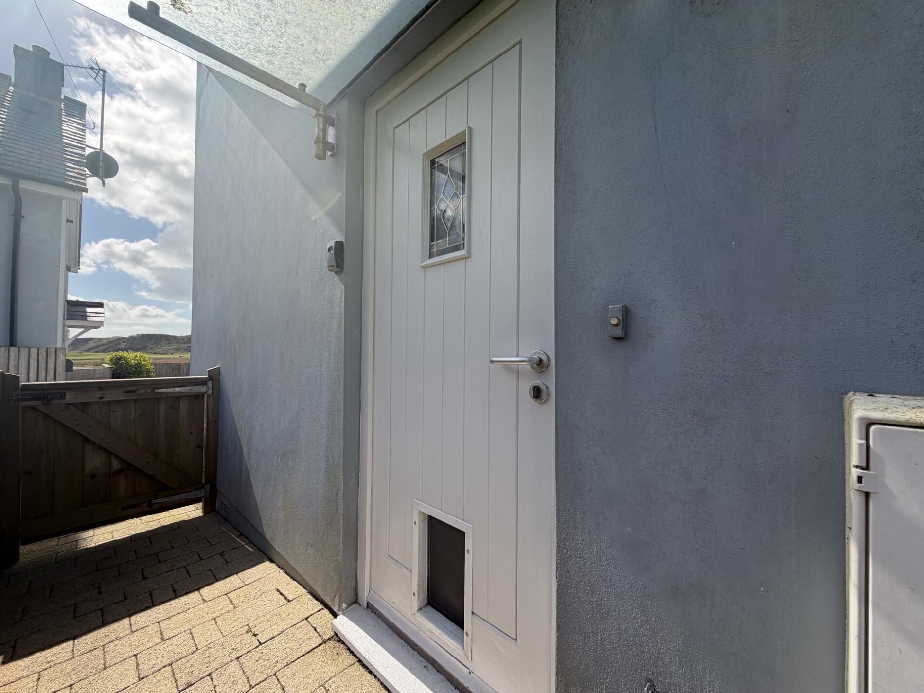 A door with a small window, a mailbox, and a wall-mounted light fixture.