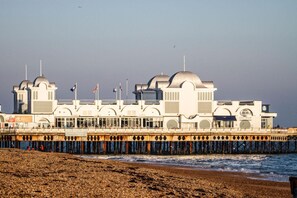A pier with a building featuring domed roofs and flags, extending into the water. - 🌊 Southsea Studio | Near the Pier | 5 Mins to the Beach! 🌊 (Portsmouth)