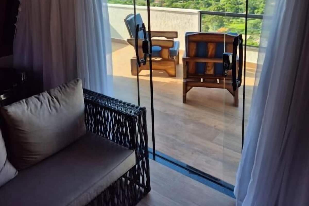 Ein Zimmer mit einer großen Schiebeglasdoor zum Außenbereich, der zwei Holzstühle bietet.