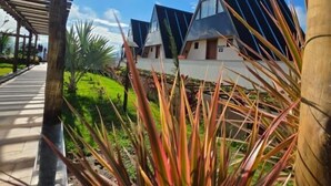 A row of modern, triangular-roofed buildings with a wooden pergola in the foreground. - Mirante Vista Nobre (Maricá)