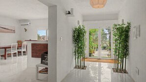 A modern interior with a dining area, a wooden cabinet, and a view through a glass door. - Jingtu Wellness & Spa Vairochana (Romo Cuevas)
