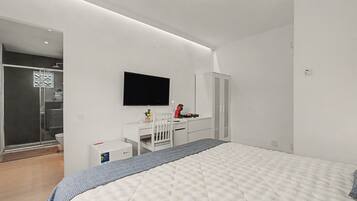 Ein modernes Schlafzimmer mit einem Bett, einem Schreibtisch, einem Stuhl, einem Fernseher und einem Kleiderschrank.