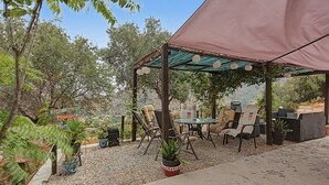 An outdoor patio area with a table and chairs, surrounded by potted plants and a view of the landscape. - Jingtu Wellness & Spa Maitreya (Romo Cuevas)