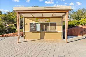 Ein Kiosk mit Speisekarte, einer Glastheke und einer Holzkonstruktion.