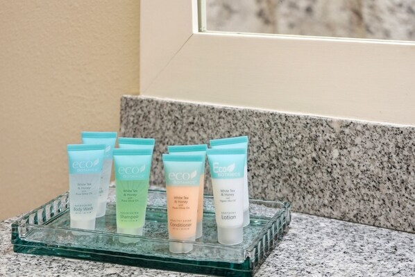 A glass tray with six eco botanics products on a granite countertop.