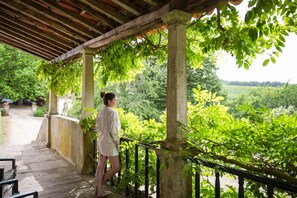 A covered outdoor area with stone columns and a wooden deck. - Feel Discovery Casa de Vilarinho de São Romão (Sabrosa)