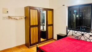 A bedroom with a bed, wardrobe, and a window with a view. - Independent Bungalow for rent at Siolim. Next to main market with parking for 2 (Siolim)