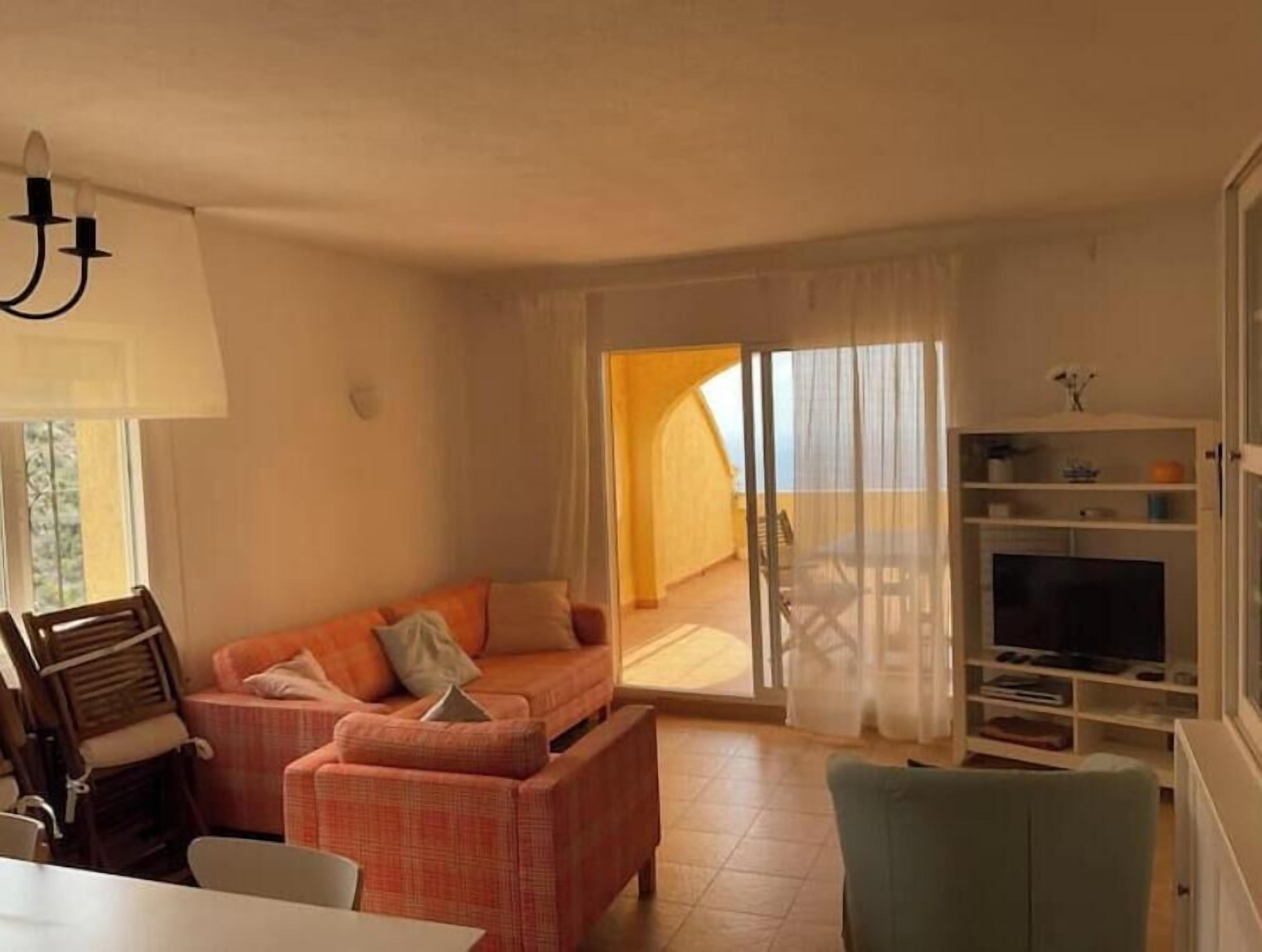 En stue med sofa, spisebord og fjernsyn.