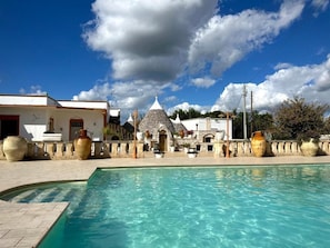 Una piscina con un edificio de piedra al fondo.