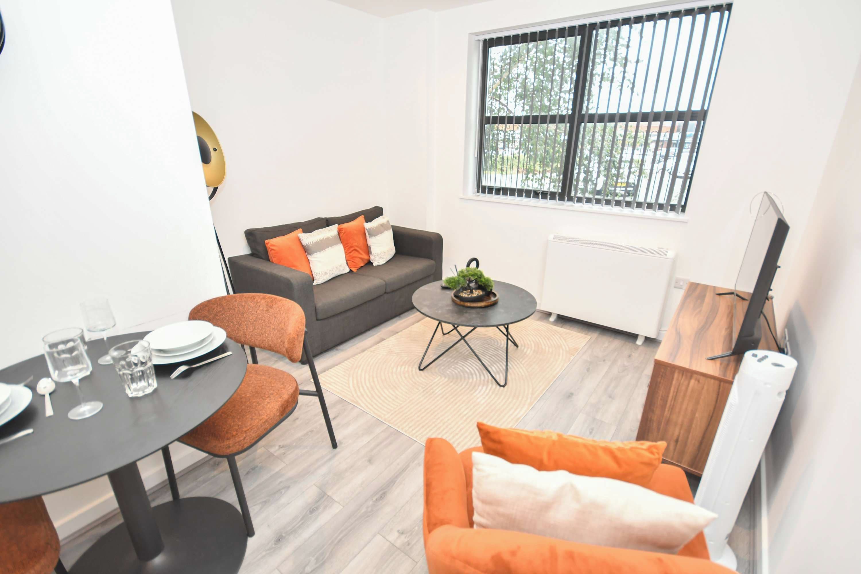 A compact living space with a sofa, a dining table, and a coffee table.