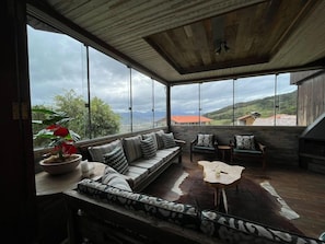 Una habitación amplia con un ventanal, un sofá, una mesa de centro y vistas al exterior.