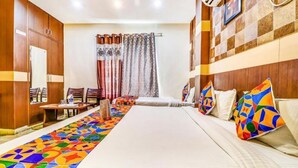 A hotel room with a large bed, a desk, and a chair. - Hotel Crystal Inn (Lucknow)