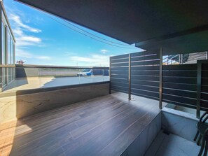 Un balcón moderno con vistas a un estacionamiento y un cielo despejado.
