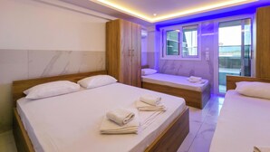 Habitació d'hotel amb dos llits, un bany i un balcó amb vistes.